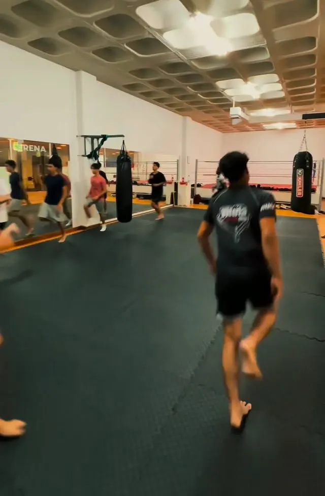 Treino no tatame, com alunos de pé a fazer exercícios de movimentação